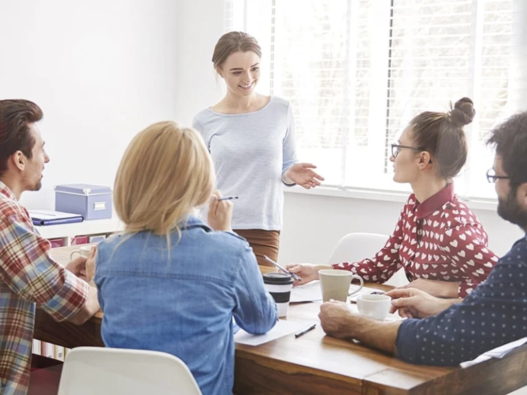 Junge Frau führt eine Gruppe von Betriebsräten durch ein Seminar – Seminare für Betriebsratsvorsitzende und Stellvertreter zu Führung, Organisation und Mitbestimmung